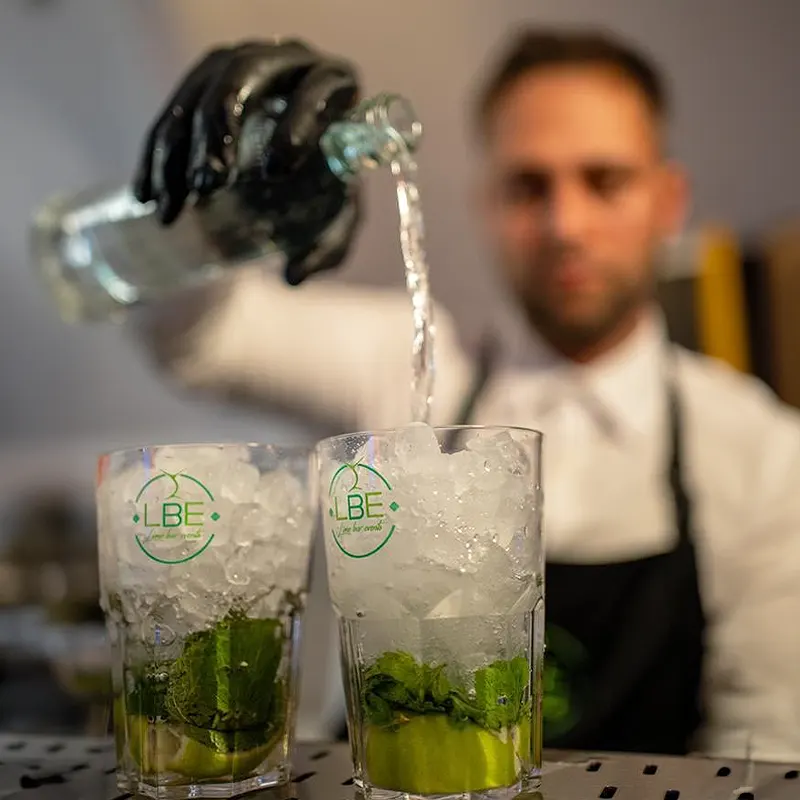 Des personnes sont assises près d'un bar mobile en train de boire leurs boissons